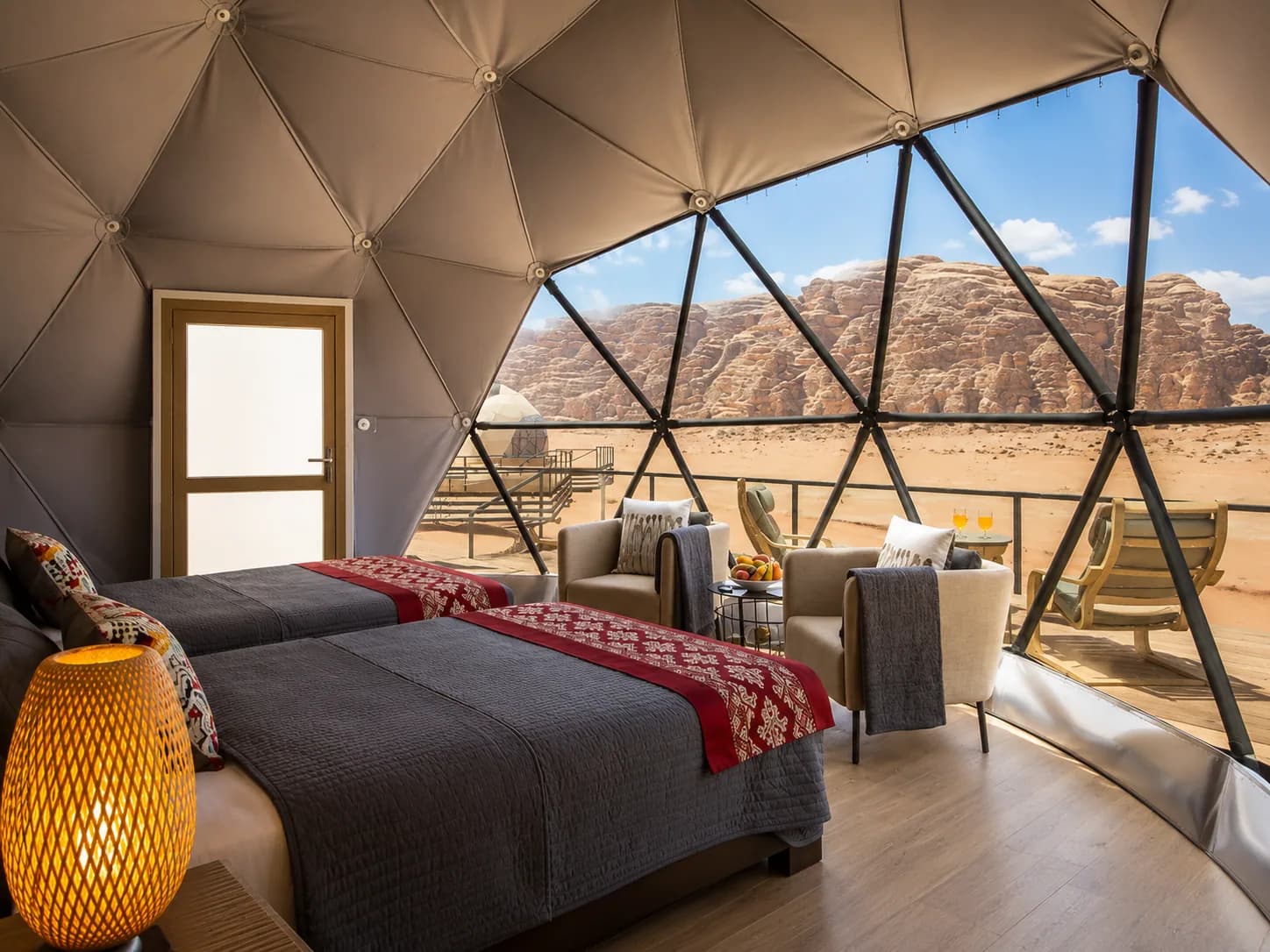 Panoramic dome room with a bed and desert view at Jamal Rum Camp.
